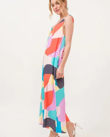 Woman wearing a colorful geometric patterned jumpsuit on a white background