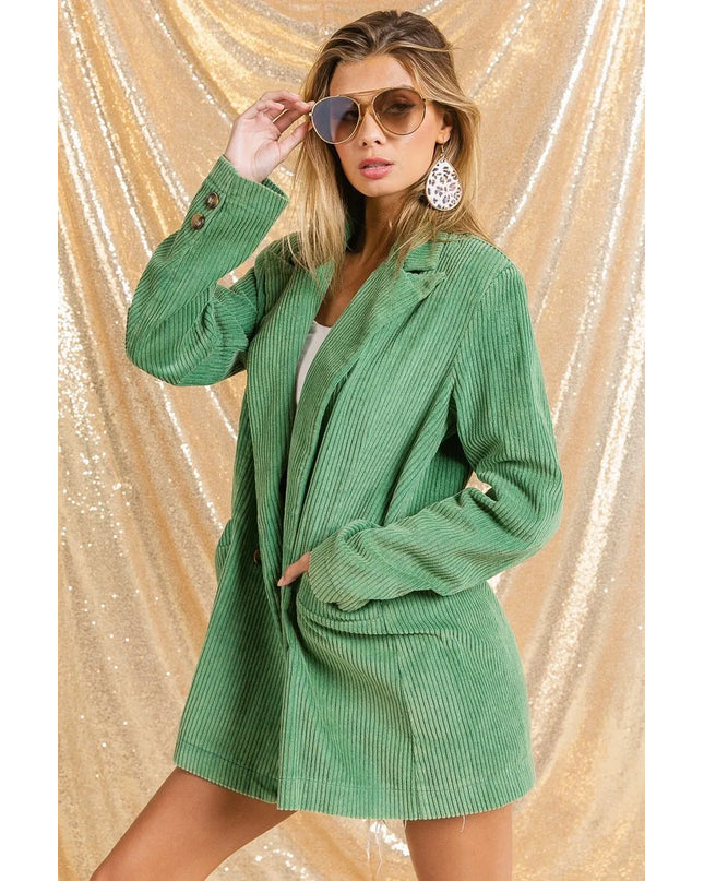 Woman wearing The Vintage Moss Blazer with sunglasses against a gold glittery background
