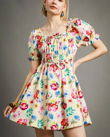 Woman wearing a colorful floral dress against a gray background