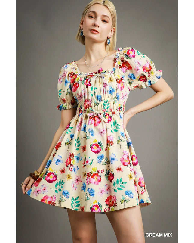 Woman wearing a colorful floral dress against a gray background