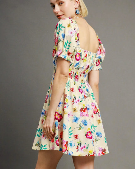Woman wearing a colorful floral dress against a gray background