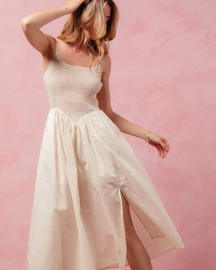 Woman wearing a white dress against a pink background