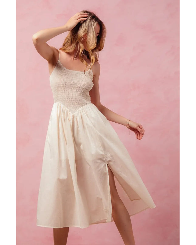 Woman wearing a white dress against a pink background