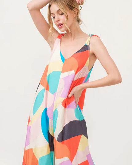 Woman wearing a colorful patterned jumpsuit on a white background