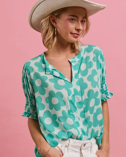 Woman wearing the Turquoise Bloom Notched Collar Blouse and white cowboy hat on a pink background