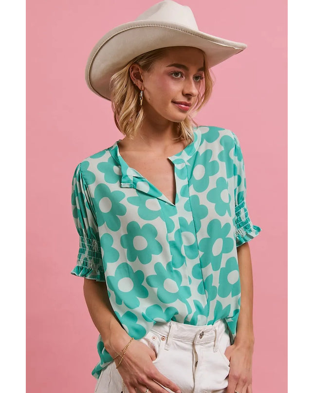 Woman wearing the Turquoise Bloom Notched Collar Blouse and white cowboy hat on a pink background