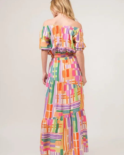 Woman wearing a colorful checkered crop top and skirt on a white background