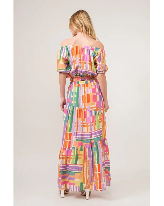 Woman wearing a colorful checkered crop top and skirt on a white background
