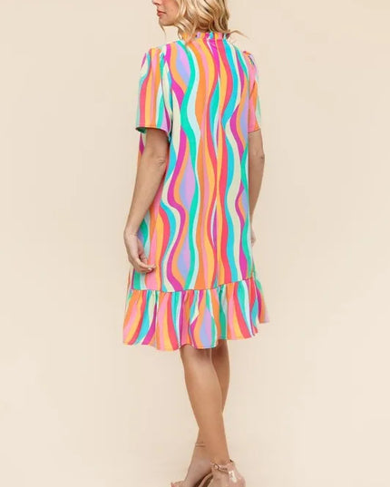 Woman wearing a colorful striped dress on a beige background