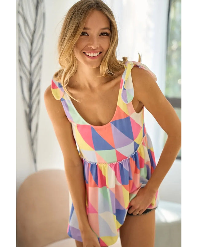 Woman wearing a colorful geometric-patterned top indoors.