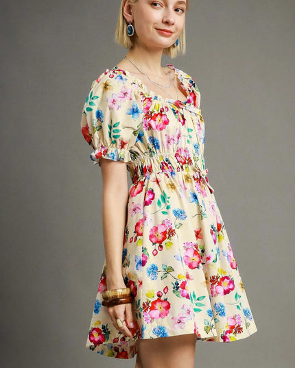 Woman wearing a colorful floral dress against a gray background