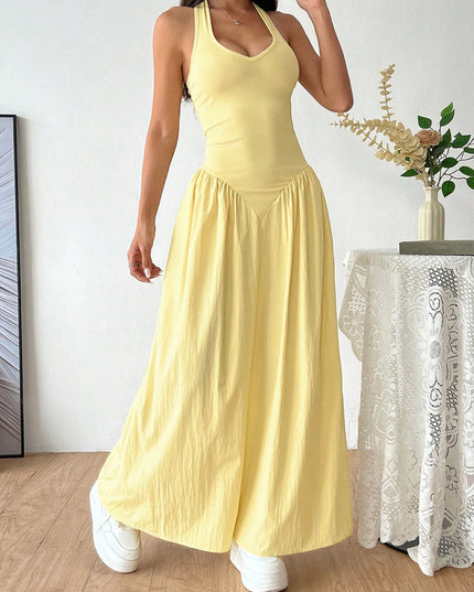 Woman wearing a yellow dress standing in a room with decorative elements.