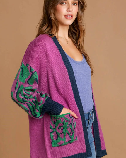 Woman wearing a purple cardigan with green patterns on a beige background