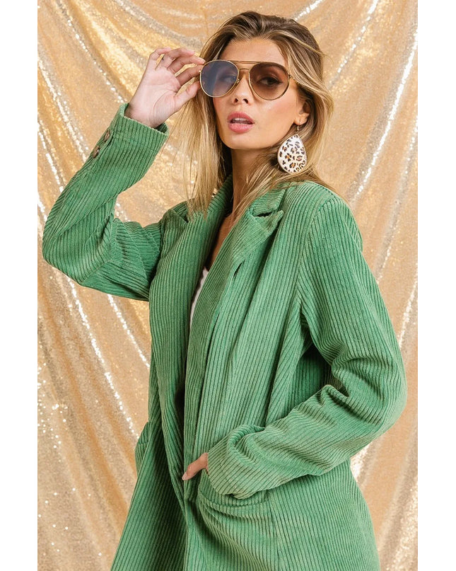 Woman wearing The Vintage Moss Blazer and sunglasses against a gold sequin background