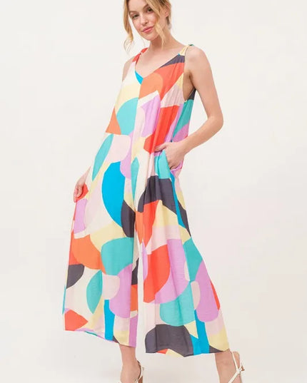 Woman wearing a colorful patterned jumpsuit on a white background