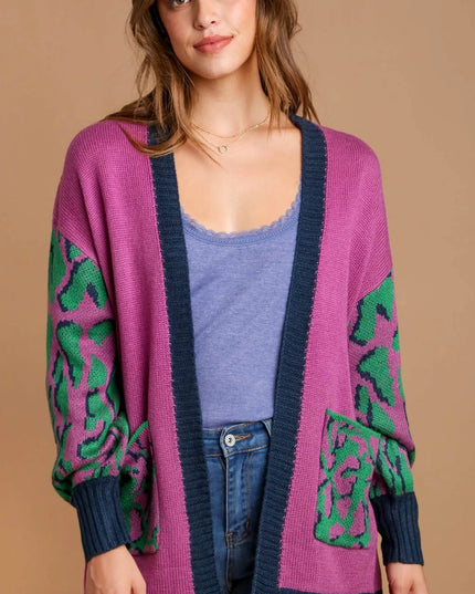 Woman wearing a pink cardigan with green patterns on a beige background
