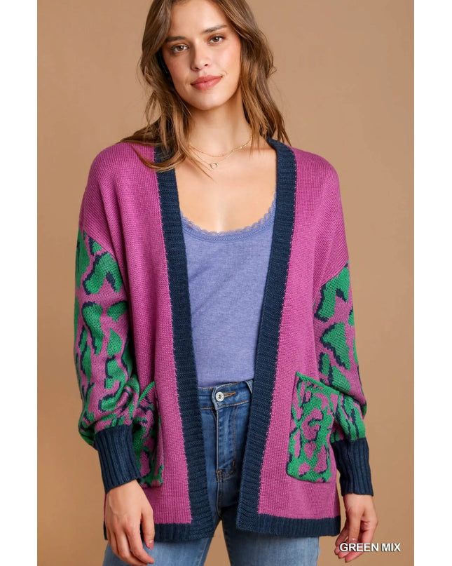 Woman wearing a pink cardigan with green patterns on a beige background