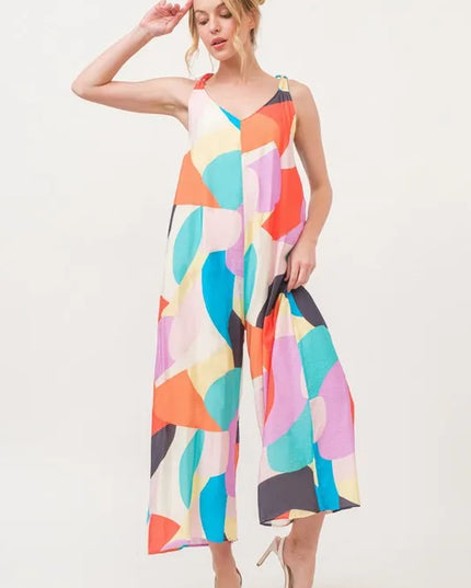 Woman wearing a colorful geometric patterned jumpsuit on a white background