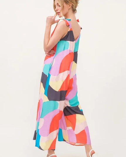 Woman wearing a colorful patterned jumpsuit on a white background