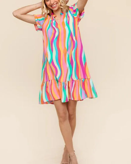 Woman wearing a colorful striped dress against a beige background