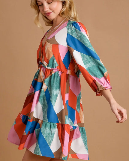 Woman wearing a colorful patterned dress on a beige background
