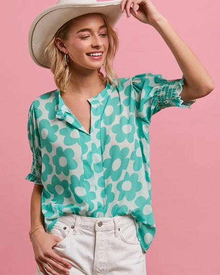 Woman wearing a Turquoise Bloom Notched Collar Blouse and cowboy hat against a pink background