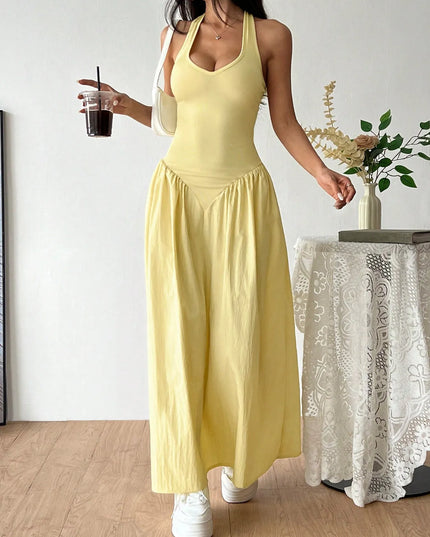 Woman in a yellow dress holding a drink indoors.
