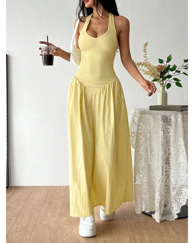 Woman in a yellow dress holding a drink indoors.