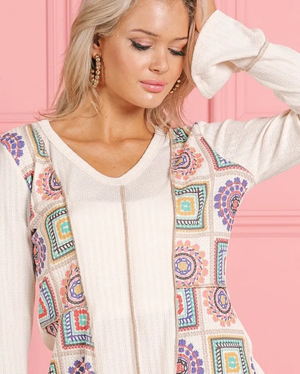 Woman wearing a Granny Square Remix V-Neck Knit Top against a pink background