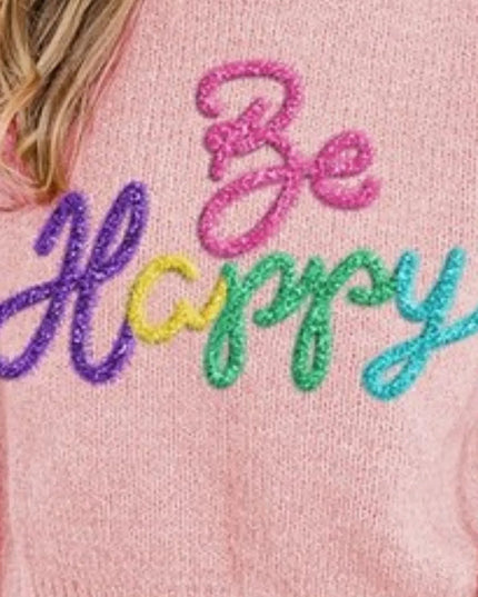 Pink sweater with 'Be Happy' text in colorful lettering