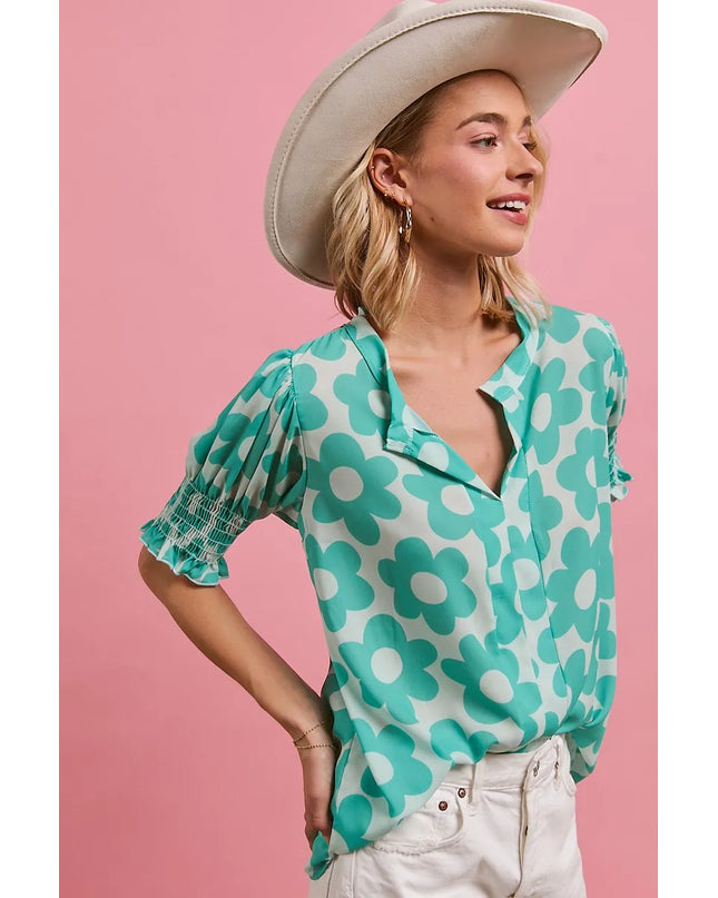 Woman wearing a Turquoise Bloom Notched Collar Blouse and white hat against a pink background