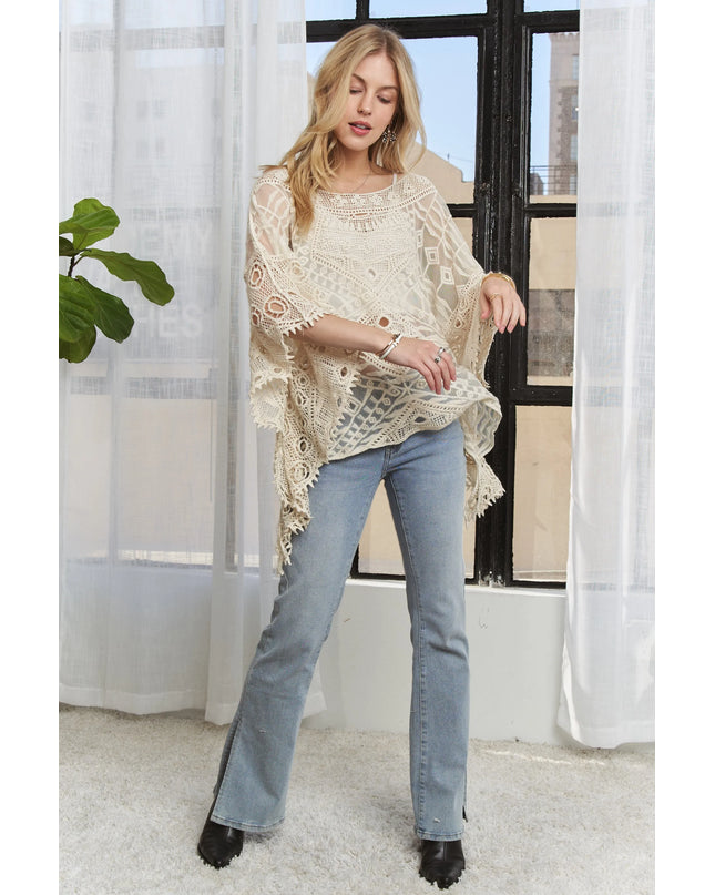 Woman wearing a Boho Mirage Crochet Lace Cover-Up and blue jeans indoors.