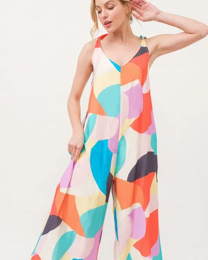 Woman wearing a colorful patterned jumpsuit on a white background