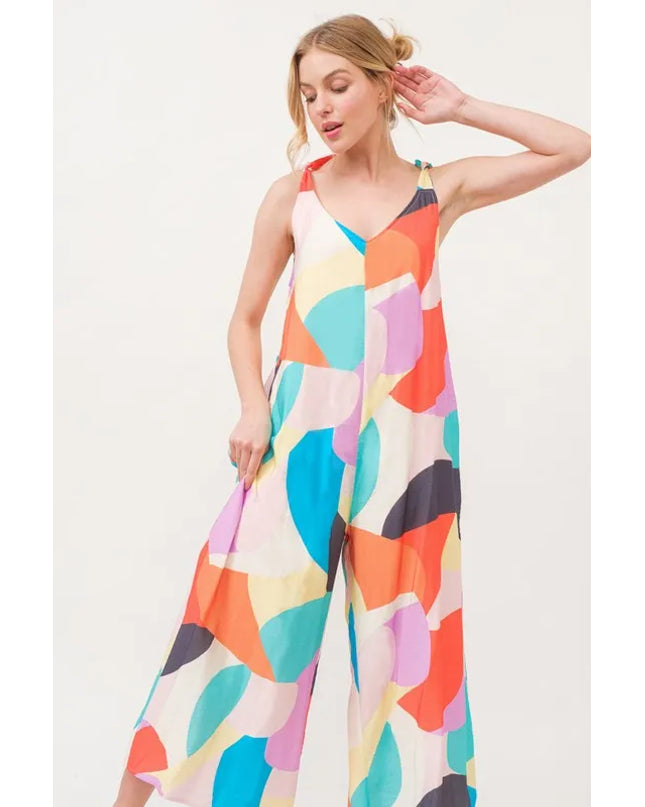 Woman wearing a colorful patterned jumpsuit on a white background