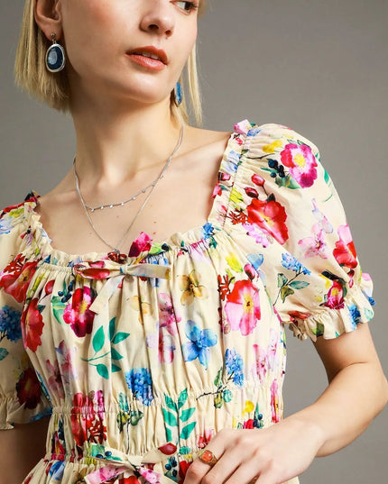 Woman wearing a colorful floral dress with a neutral background