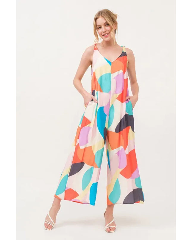 Woman wearing a colorful geometric patterned jumpsuit on a white background