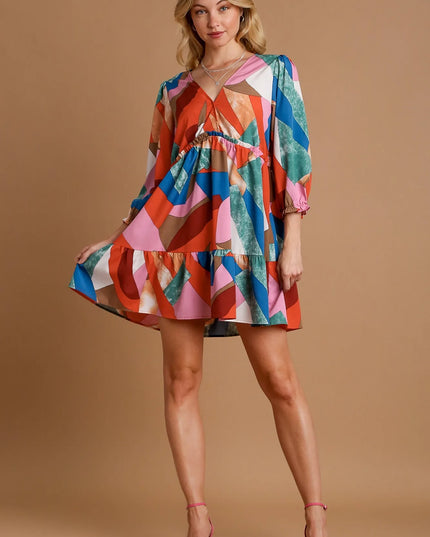 Woman wearing a colorful dress with a mix pattern on a beige background