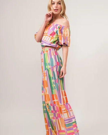 Woman wearing a colorful checkered outfit on a plain background