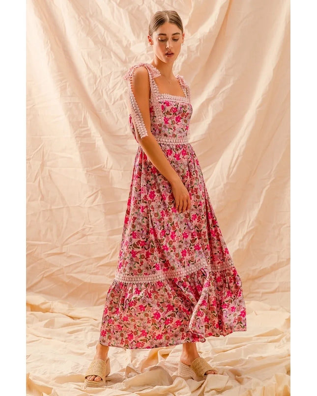 Woman wearing a Wild Bloom Smocked Maxi Dress against a beige fabric background